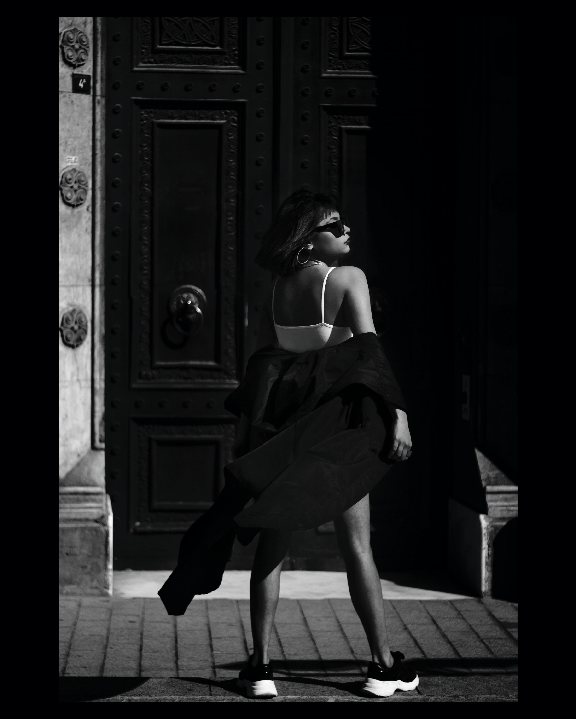 woman in black dress standing on gray concrete floor