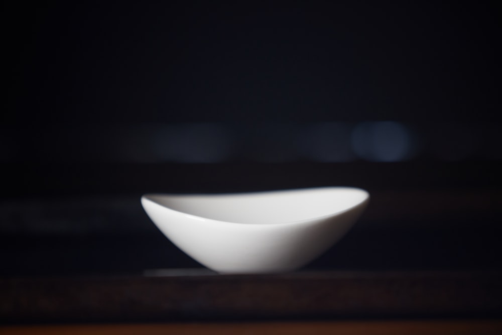 white ceramic bowl on brown wooden table