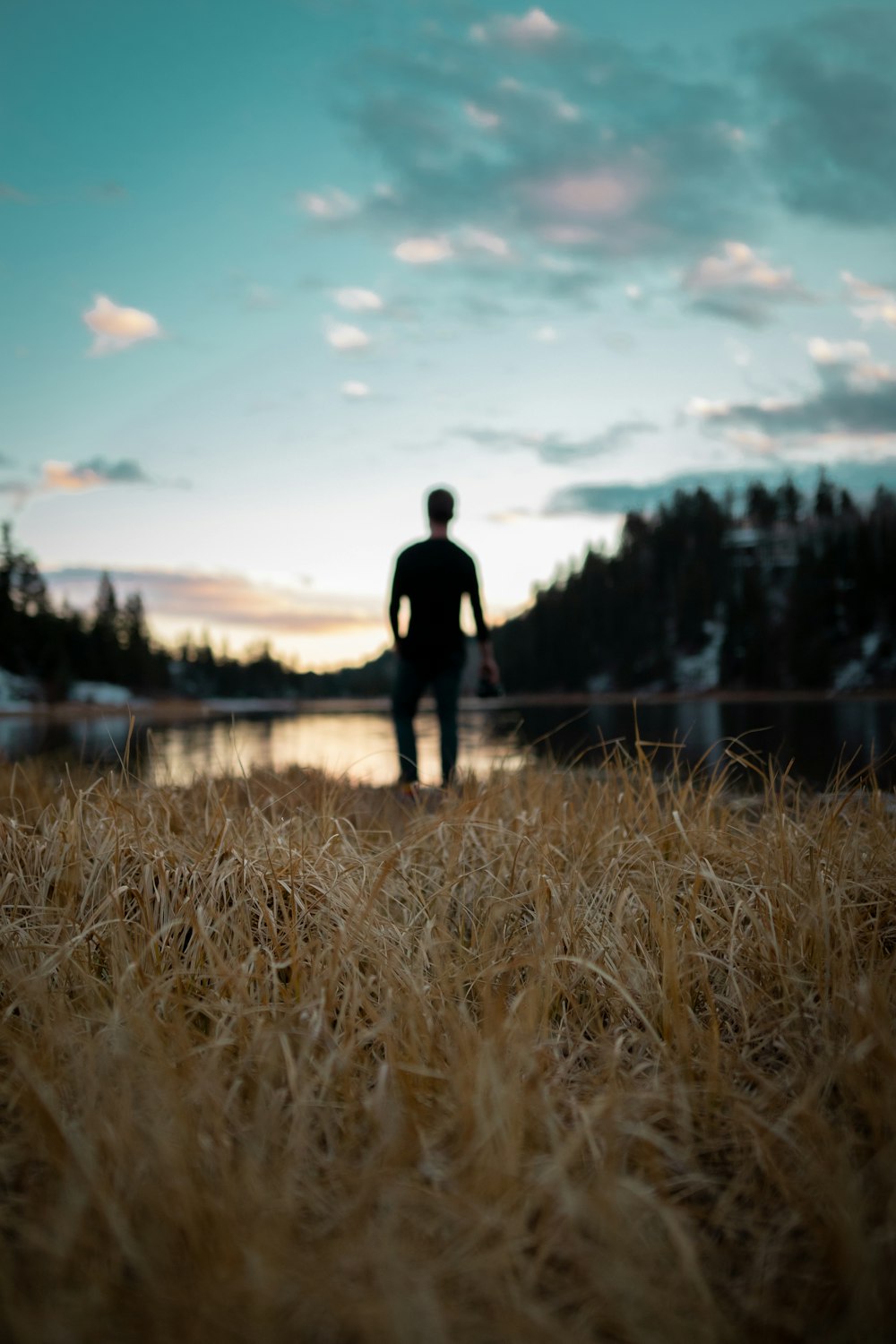 man in black jacket standing on brown grass field during daytime