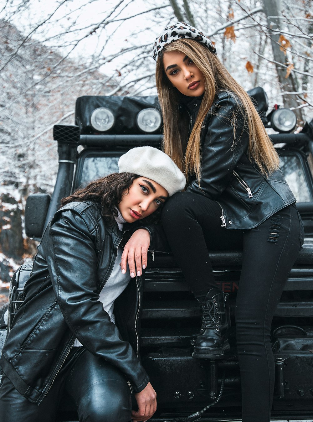 woman in black leather jacket and white scarf sitting on black car