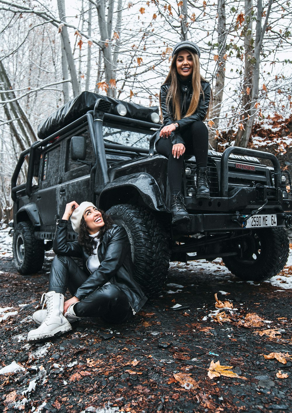 woman in black leather jacket sitting on black jeep wrangler