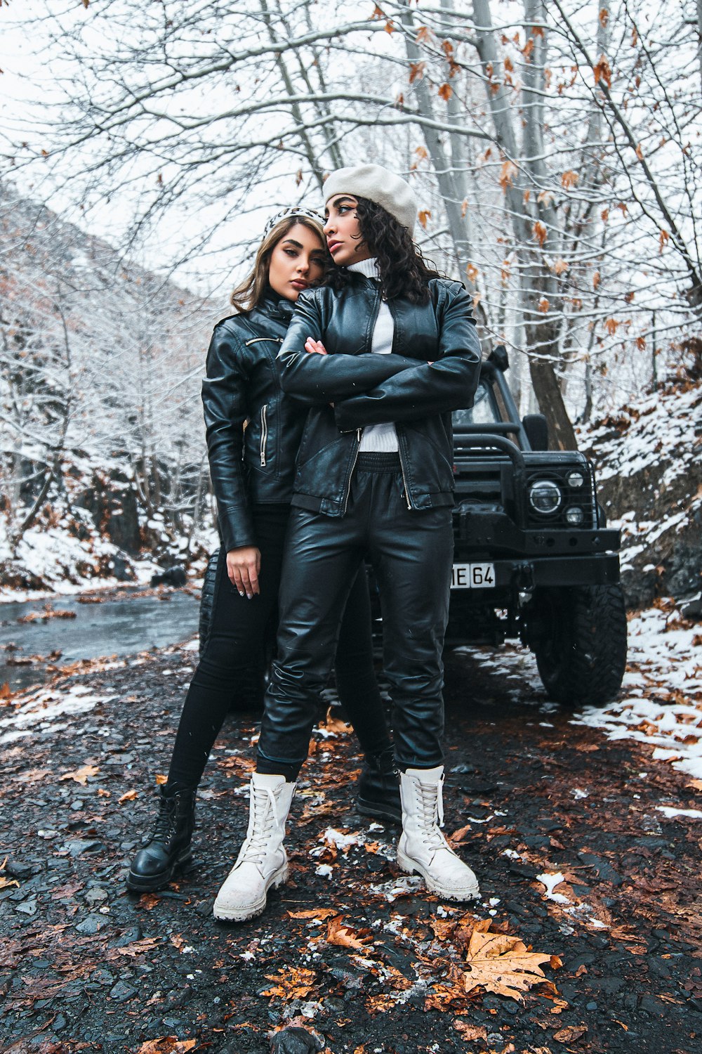 woman in black leather jacket and black pants standing on black jeep wrangler