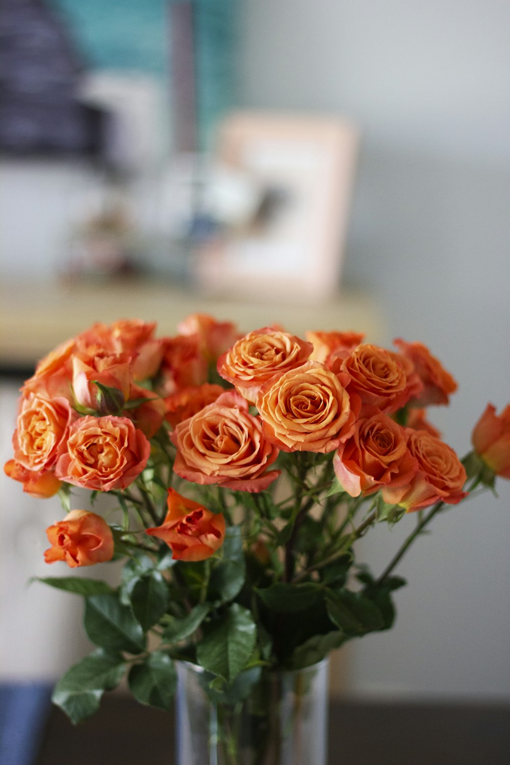 透明なガラスの花瓶にオレンジ色のバラ