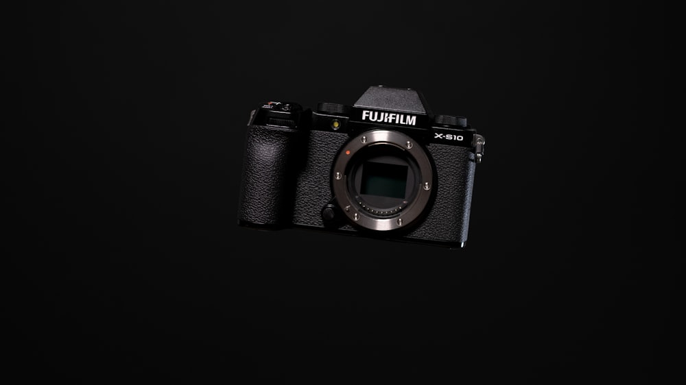 black fujifilm dslr camera on black surface