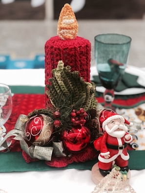 A festive table centerpiece featuring handcrafted decorations and candles.