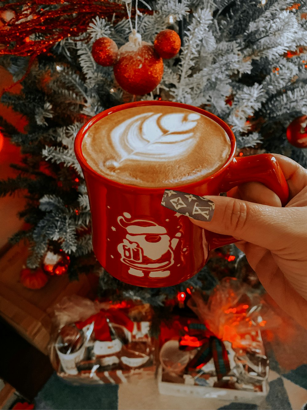 person holding red and white ceramic mug with coffee