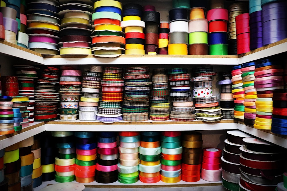 assorted color thread roll on white wooden shelf