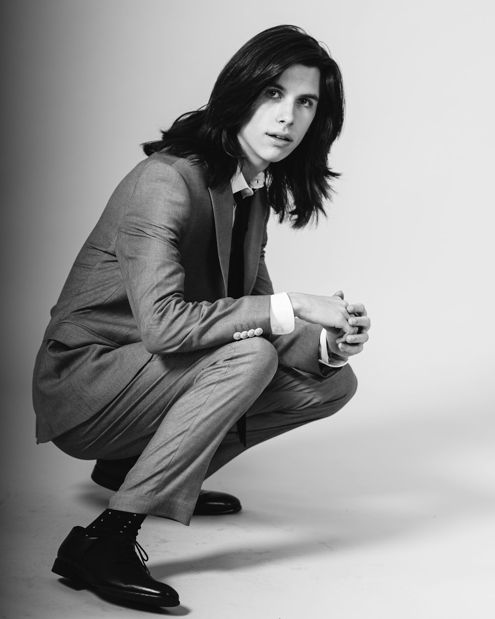 woman in black blazer and brown pants sitting on floor