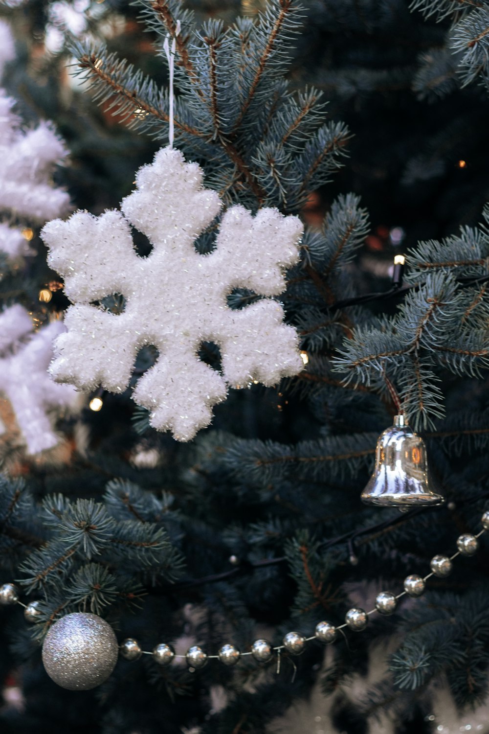 white snow flakes on green pine tree