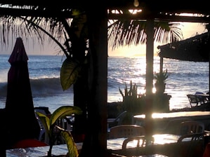 Sunset view of Villa Colina’s terrace overlooking La Ropa Beach with palm trees swaying gently.