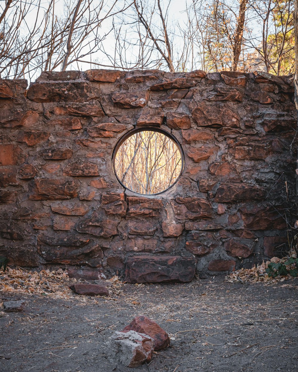 brown and black round mirror on brown brick wall