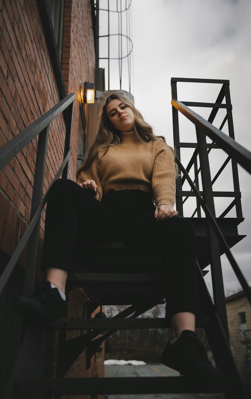woman in brown sweater sitting on brown wooden bench