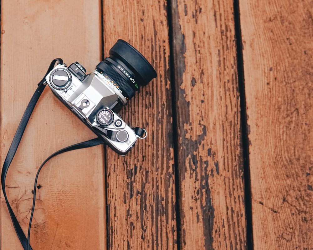 black and silver dslr camera on brown wooden surface