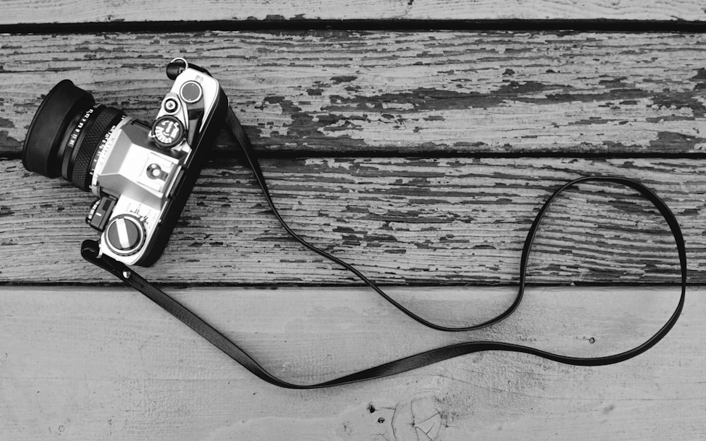 black and silver camera on wooden surface