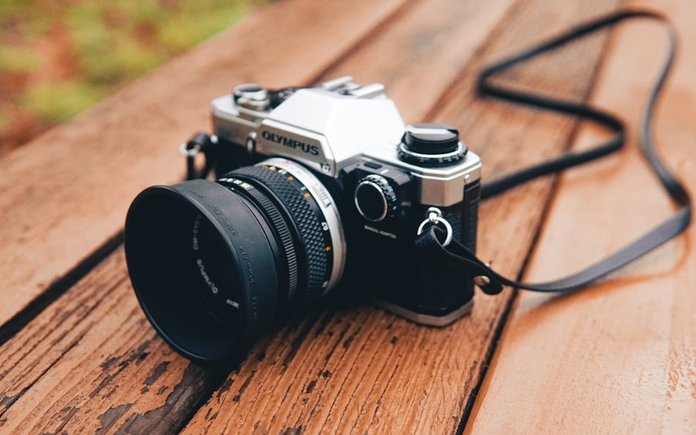 black and silver nikon dslr camera on brown wooden table