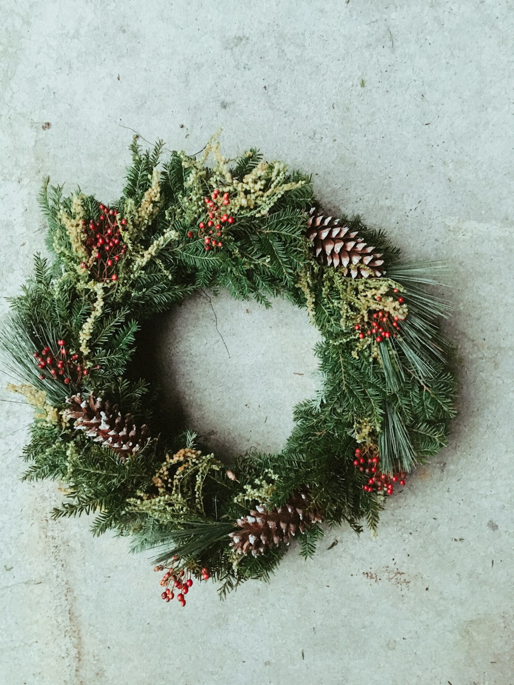 green and red pine cone wreath