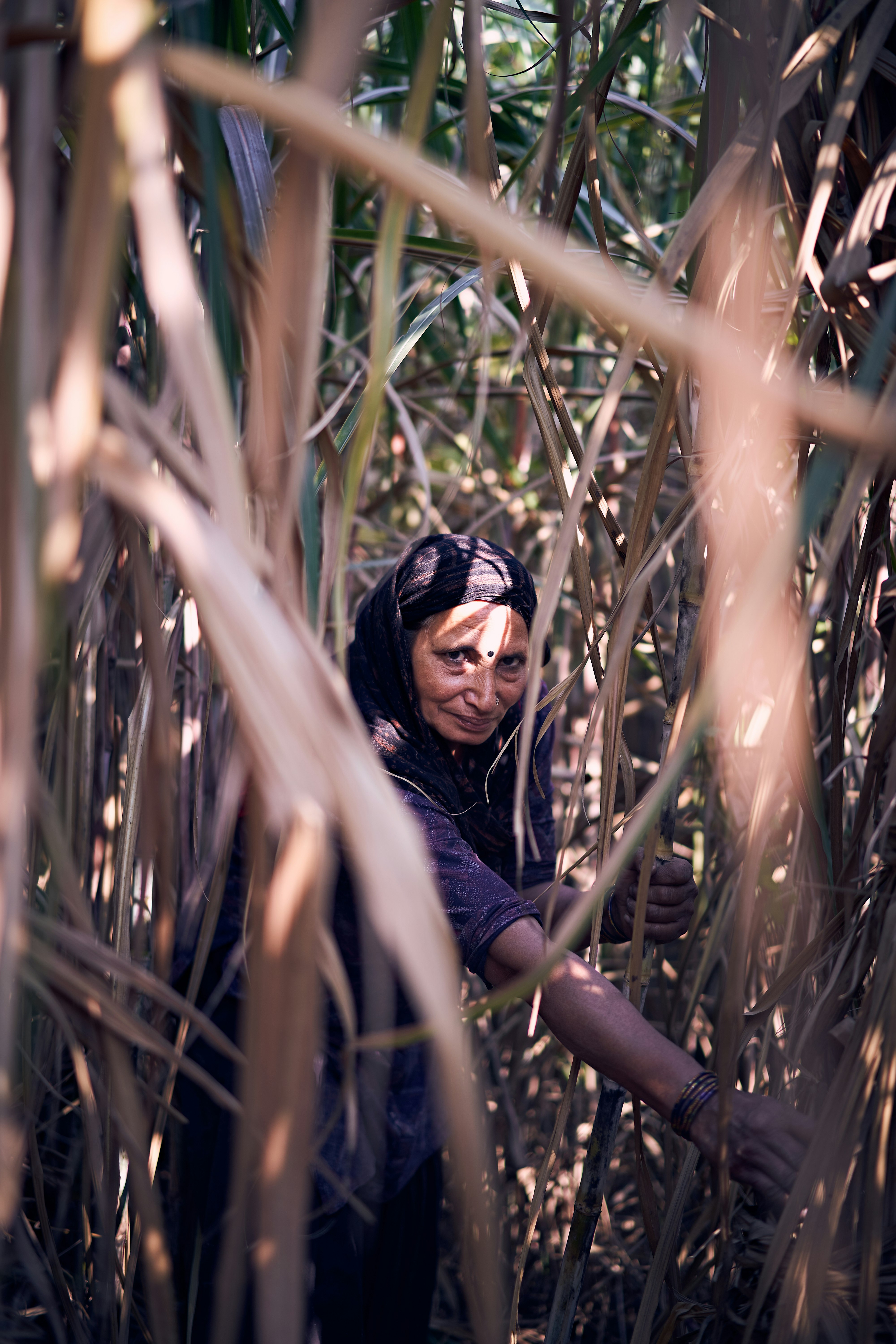 woman in black long sleeve shirt wearing black sunglasses standing on brown grass field during daytime