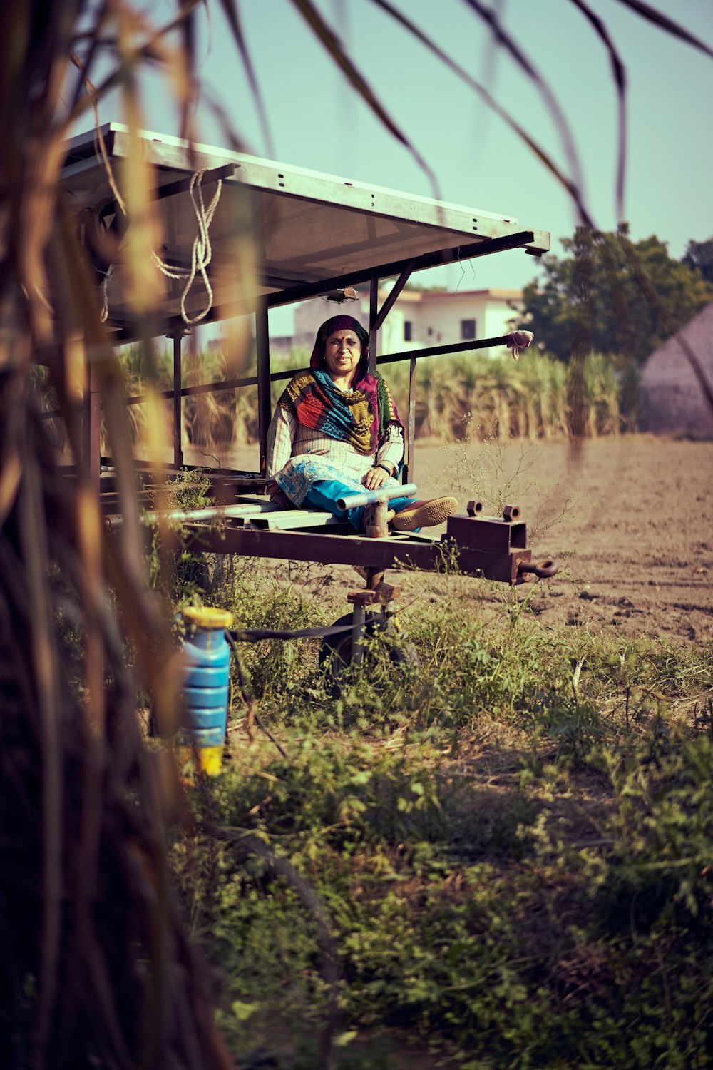 woman in green jacket sitting on brown wooden bench during daytime