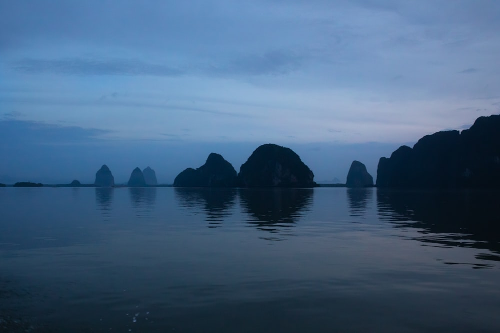 Silueta de la montaña cerca del cuerpo de agua durante el día