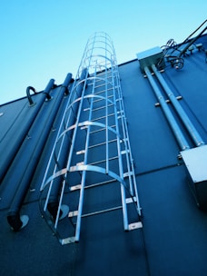 A row of GI hot-dip galvanized ladder cable trays installed in an industrial setting.