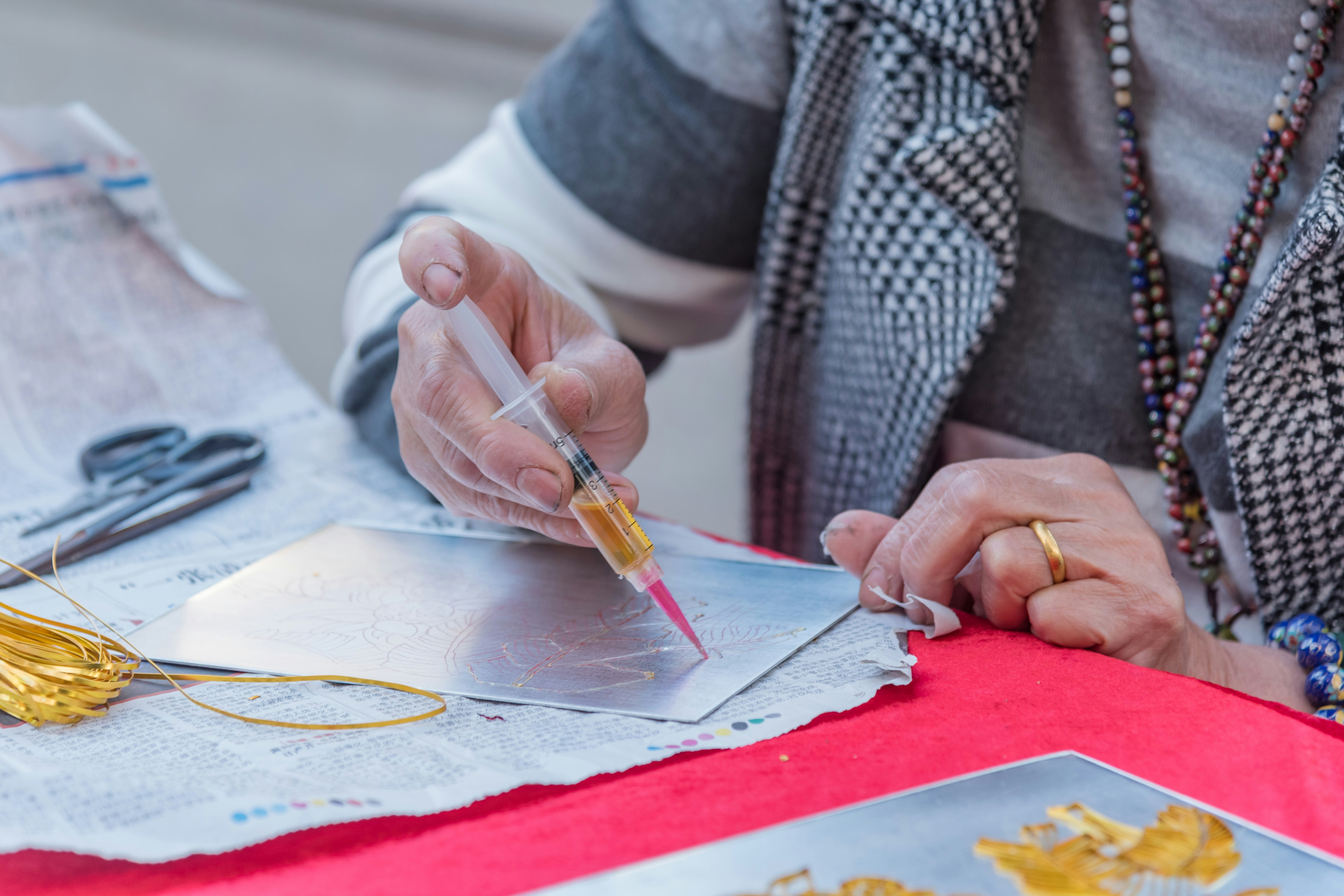 person in gray and black long sleeve shirt holding orange and white pen
