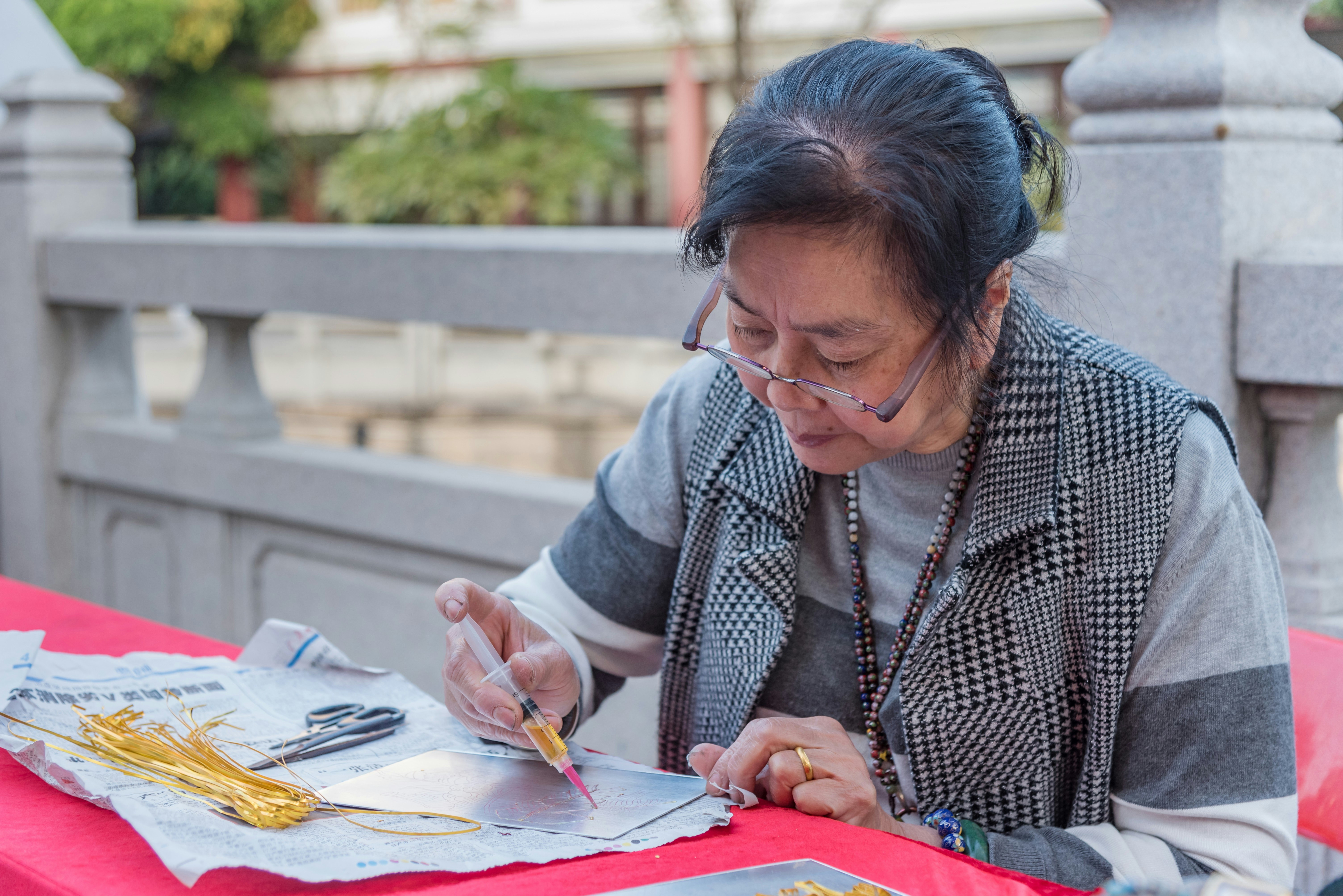 woman in gray cardigan writing on paper