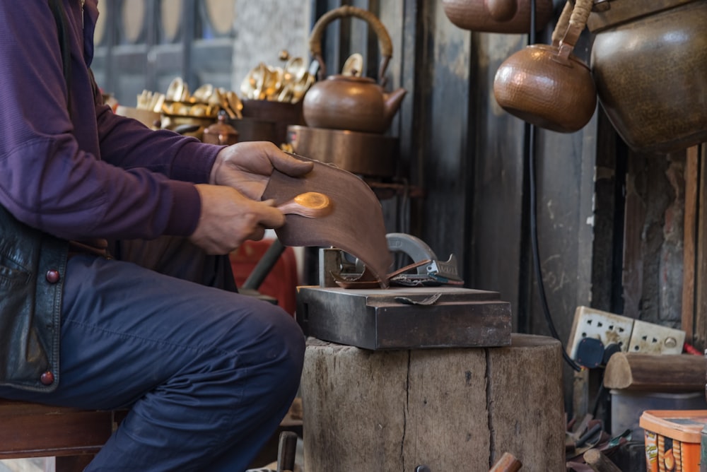 person in blue denim jeans holding brown kettle