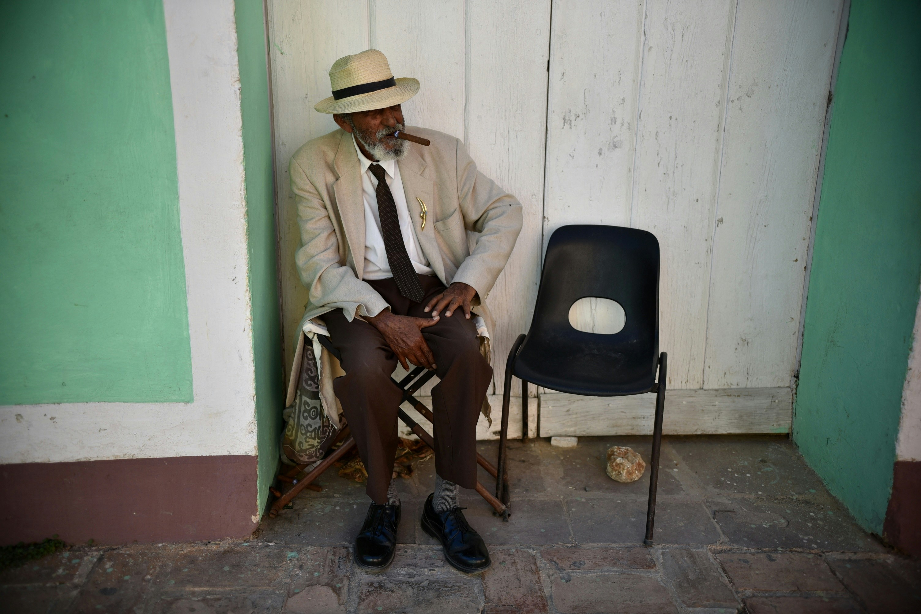 man in white suit sitting on chair