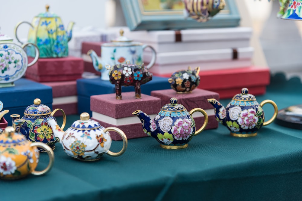 purple and white floral teapot on blue textile