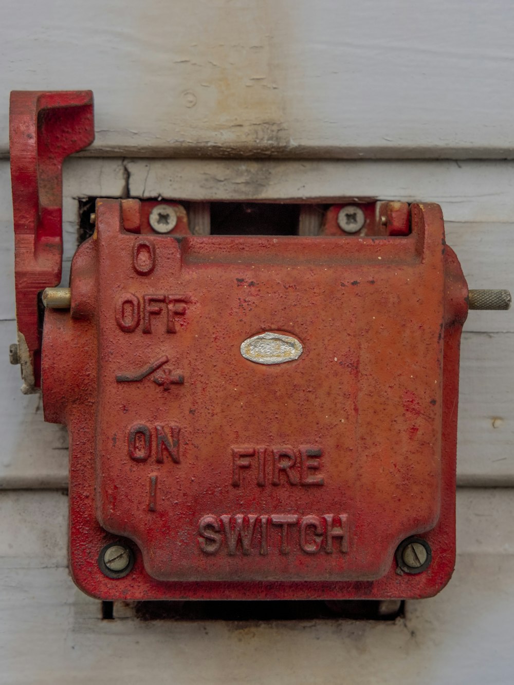 red metal door lock on white wooden wall