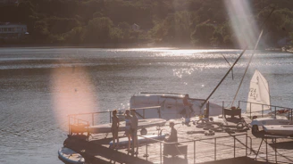 A lively gathering of electric boat enthusiasts docked at a sunny marina, sharing stories and smiles.