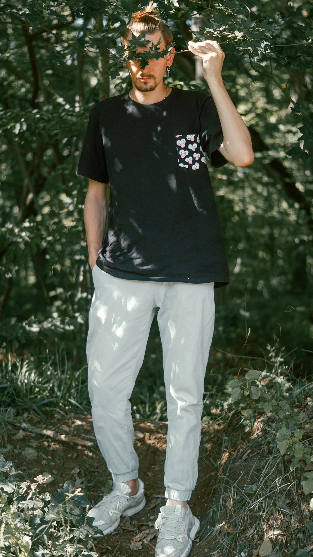 man in black crew neck t-shirt and white pants standing on green grass field during