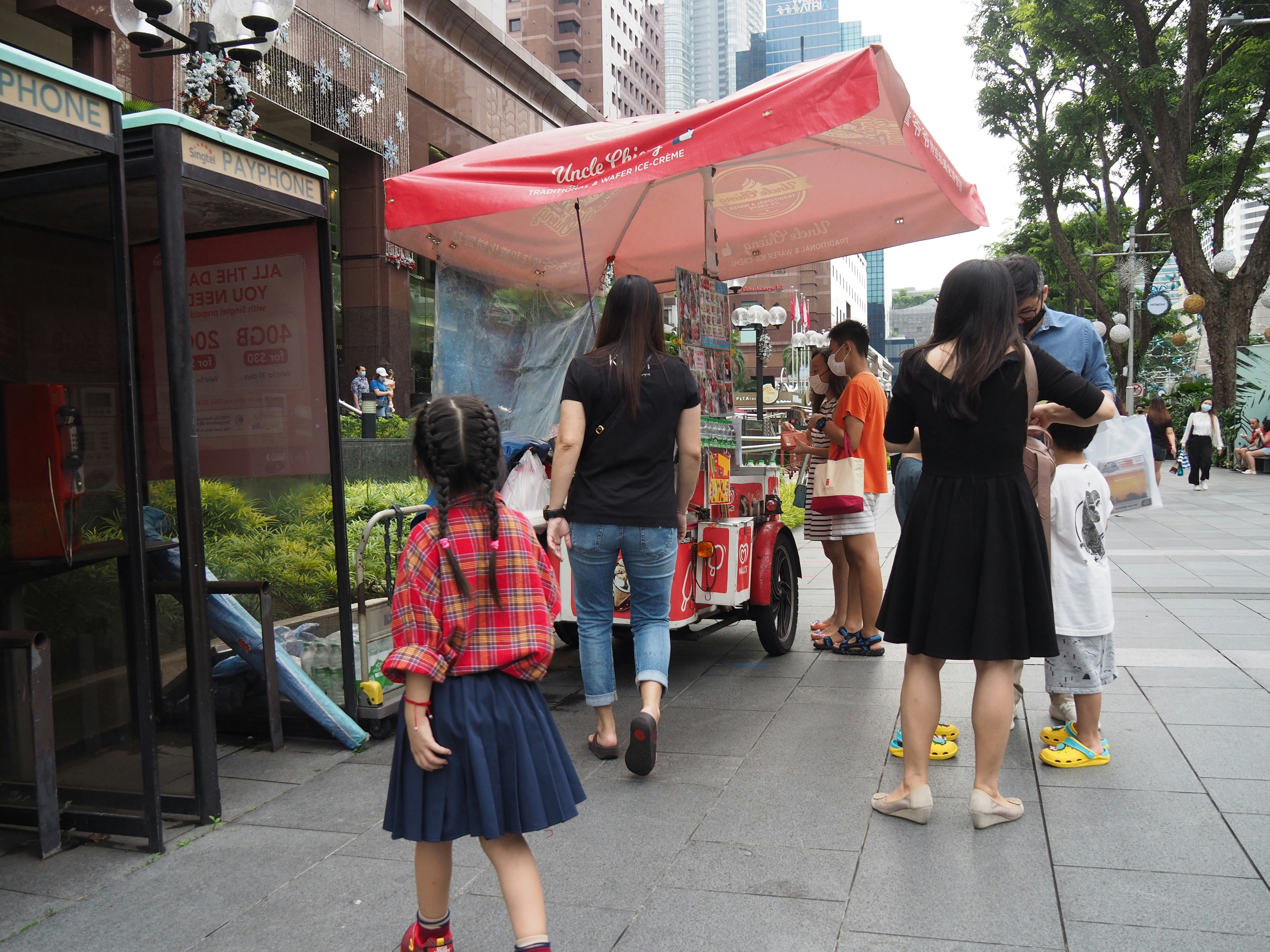 girl in red and white plaid dress shirt standing beside woman in black skirt