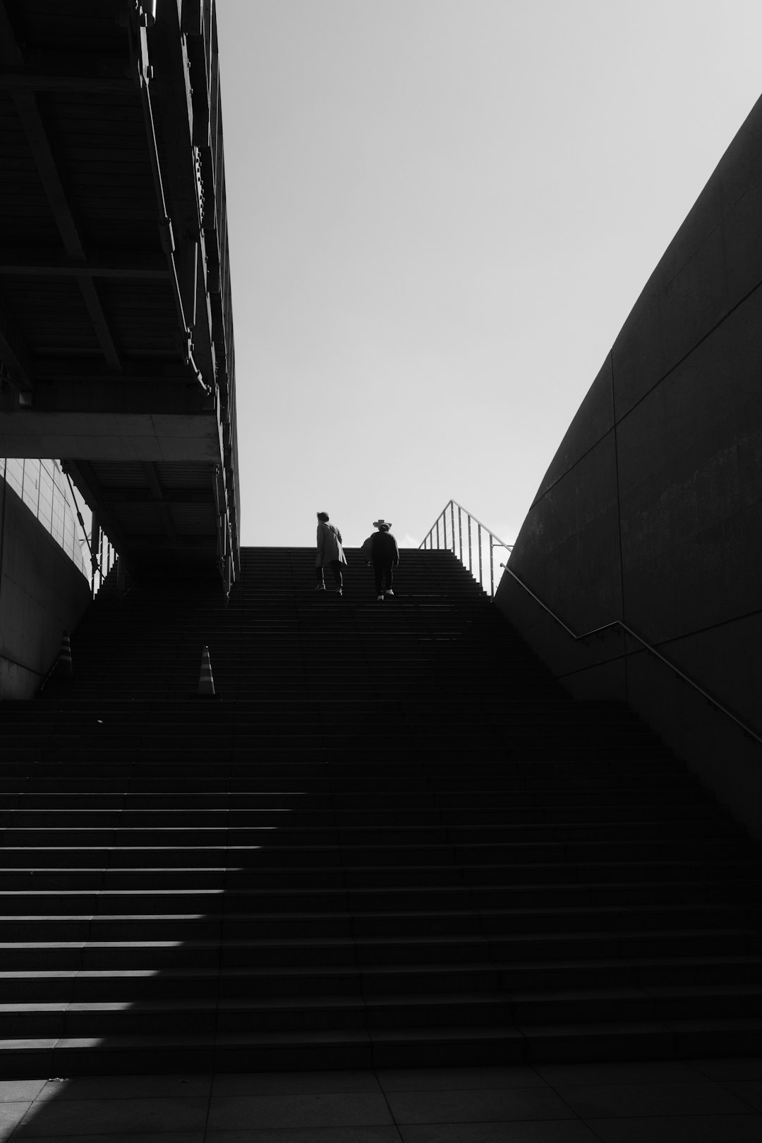 grayscale photo of 2 person walking on stairs