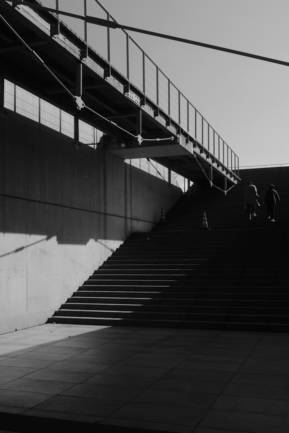 grayscale photo of people walking on stairs