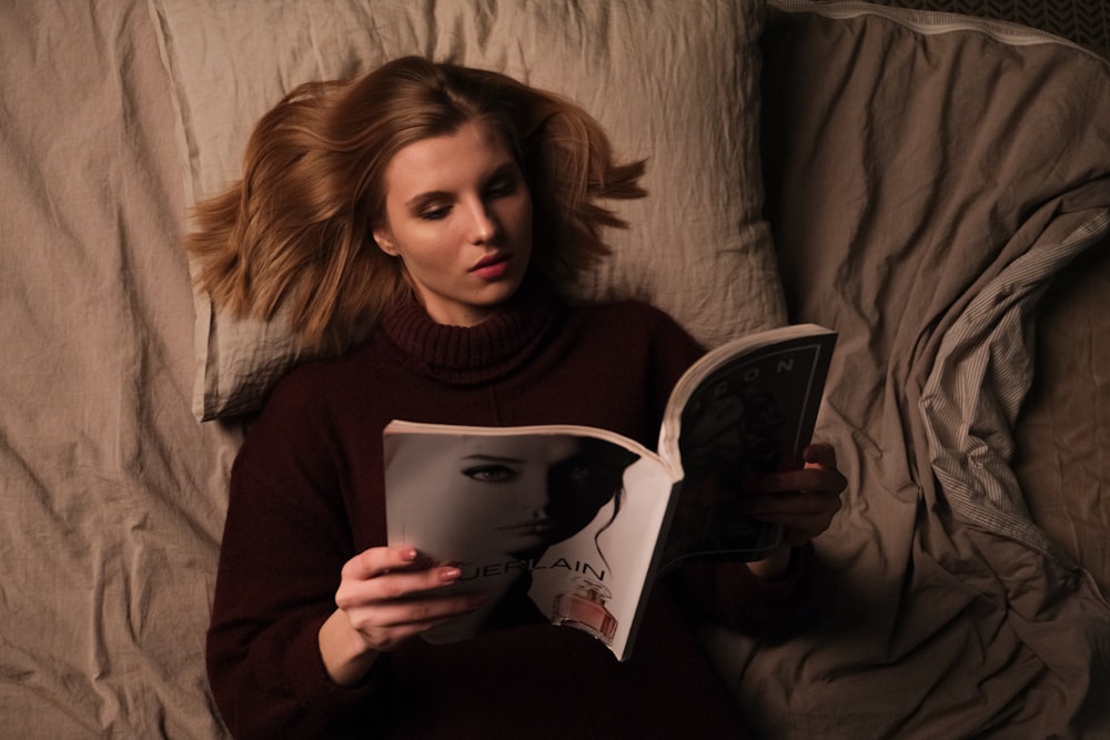 woman in gray sweater holding book