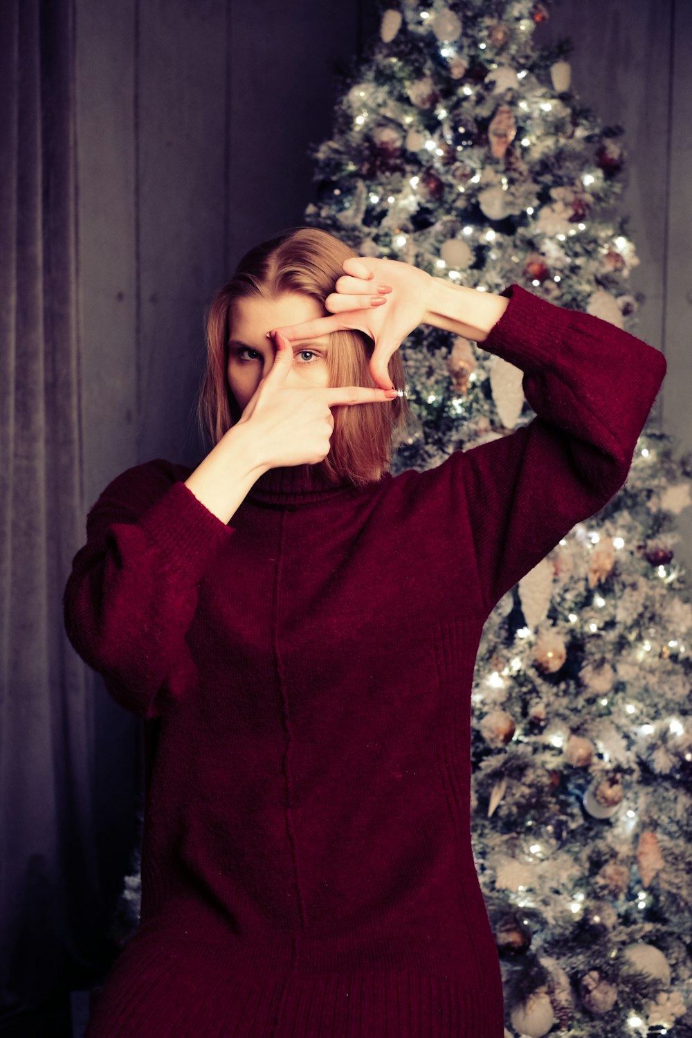 woman in red sweater covering her face with her hands