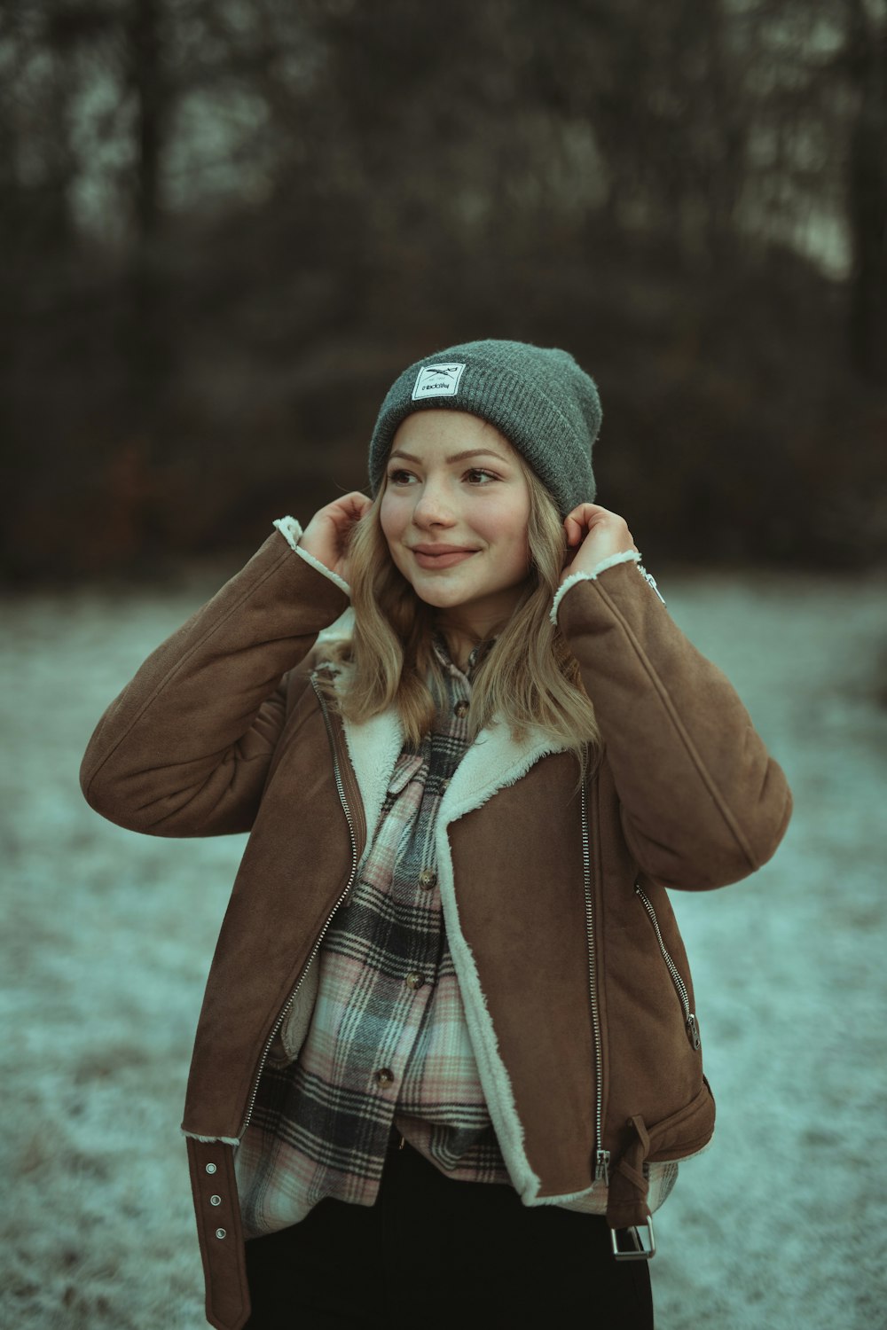 woman in brown coat and gray knit cap