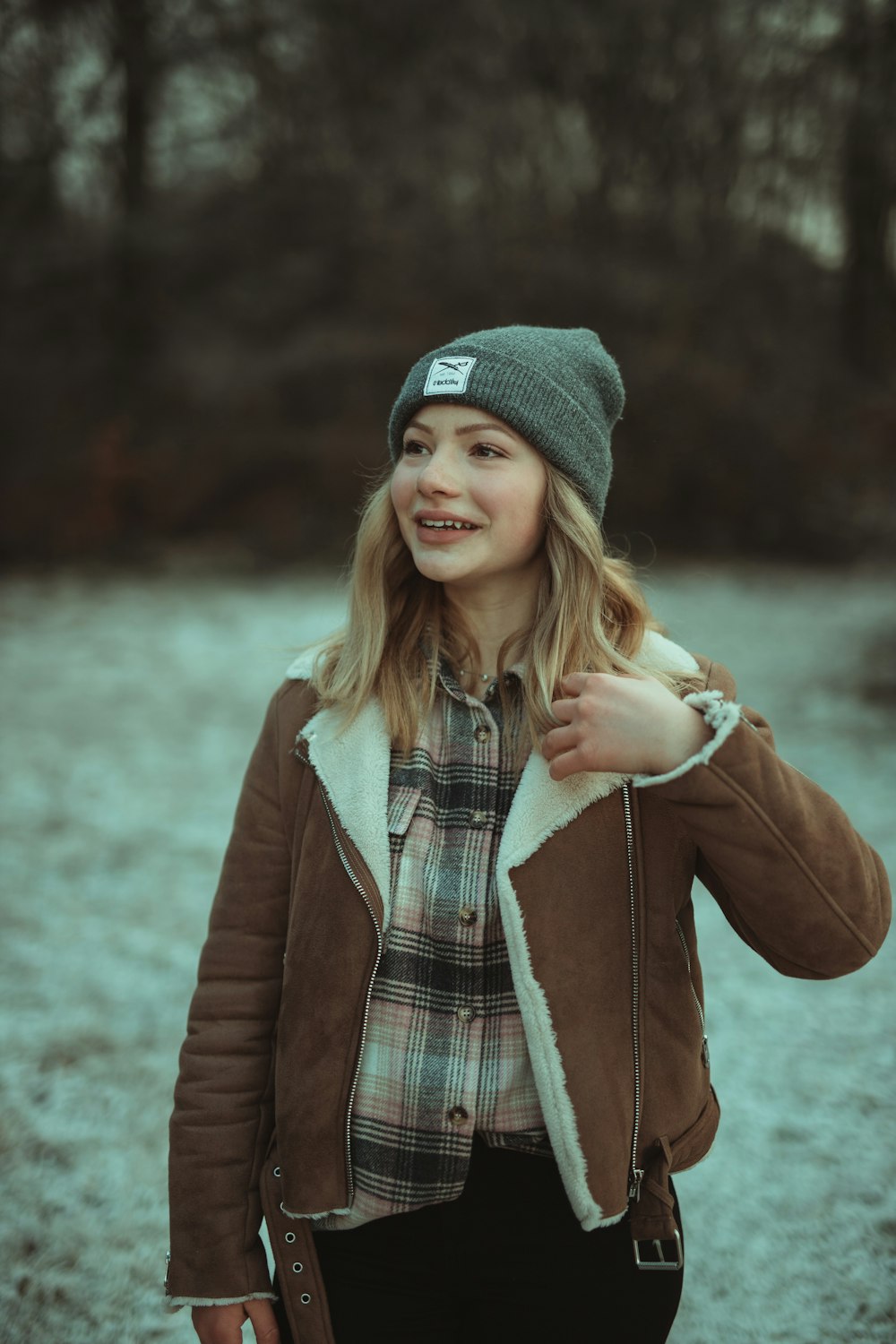 woman in brown coat and gray knit cap