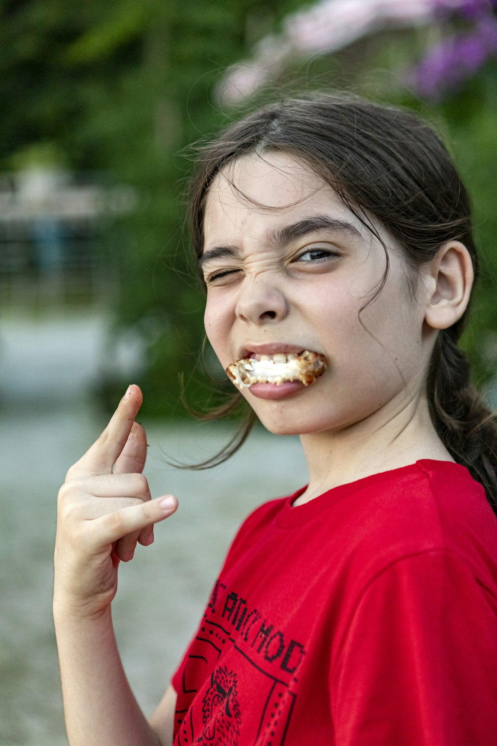 girl in red crew neck shirt eating bread