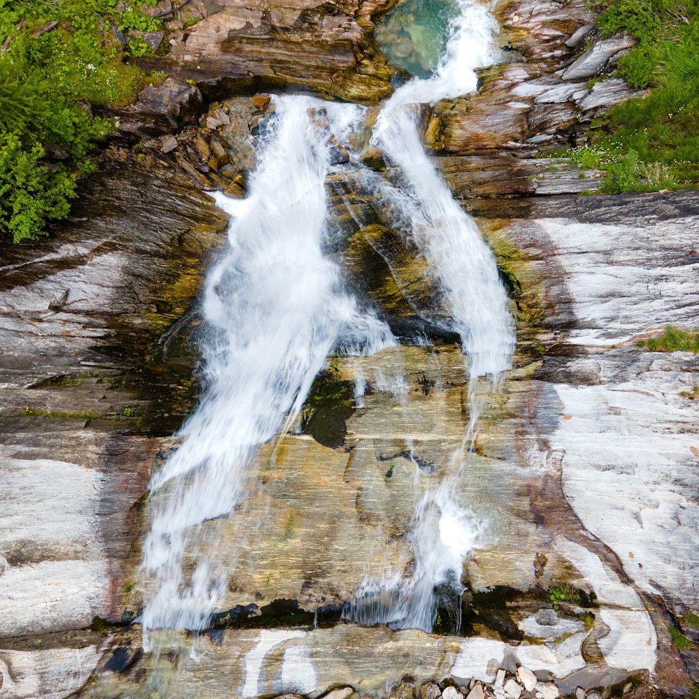 water falls on brown rocky mountain