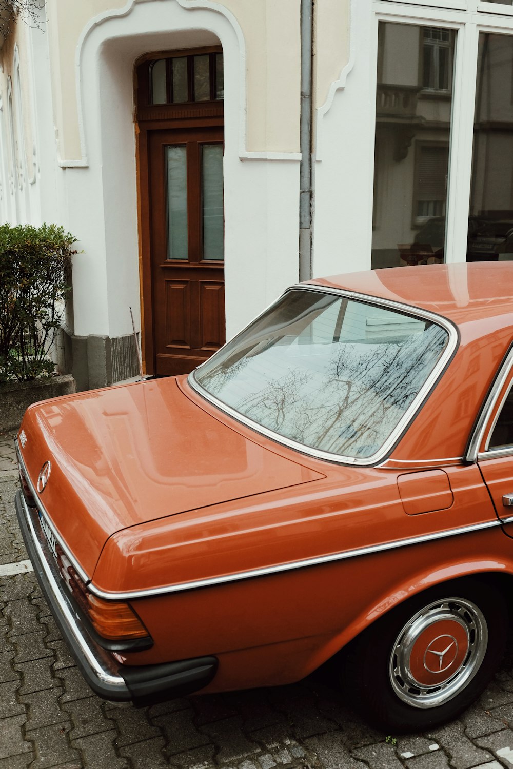 red car parked near white building