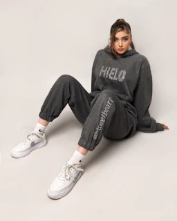 Model posing in a cozy, pastel-toned hoodie and leggings set from essência ágil.