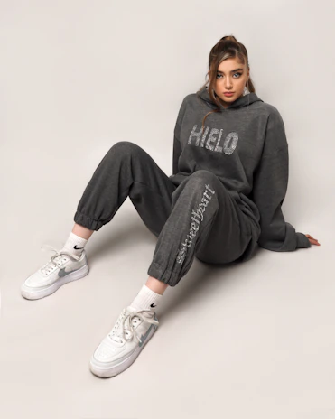 Model posing in a cozy, pastel-toned hoodie and leggings set from essência ágil.