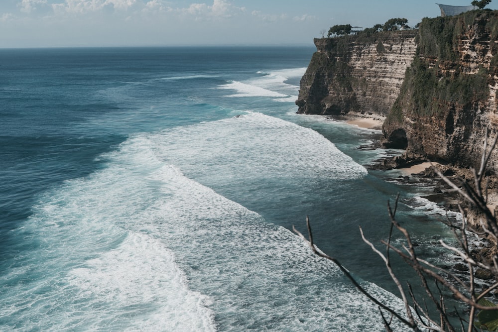 brown rocky cliff by the sea during daytime