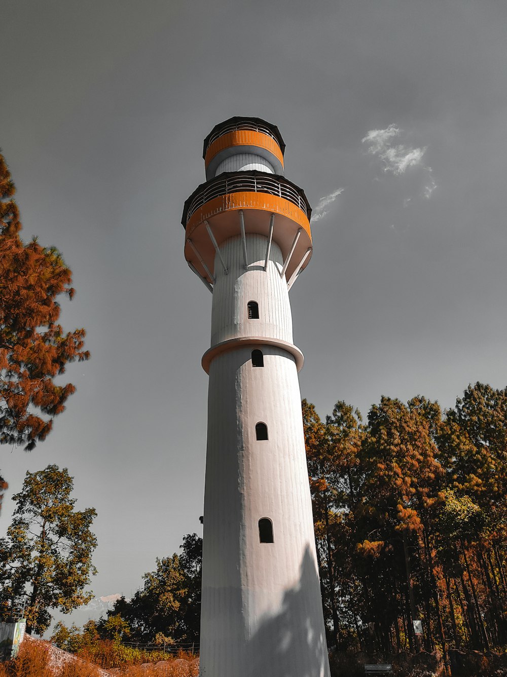 white and black lighthouse under cloudy sky during daytime