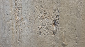 Close-up of a technician inspecting building concrete for wear.