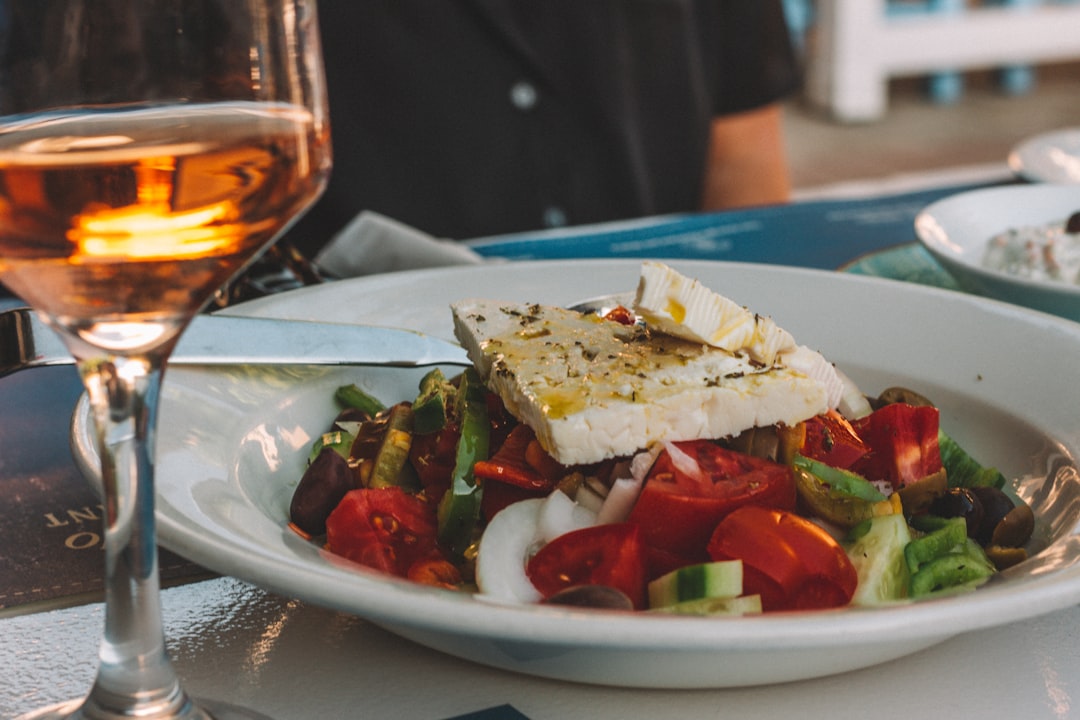 sliced tomato and cucumber on white ceramic plate, A classic Greek salad.
