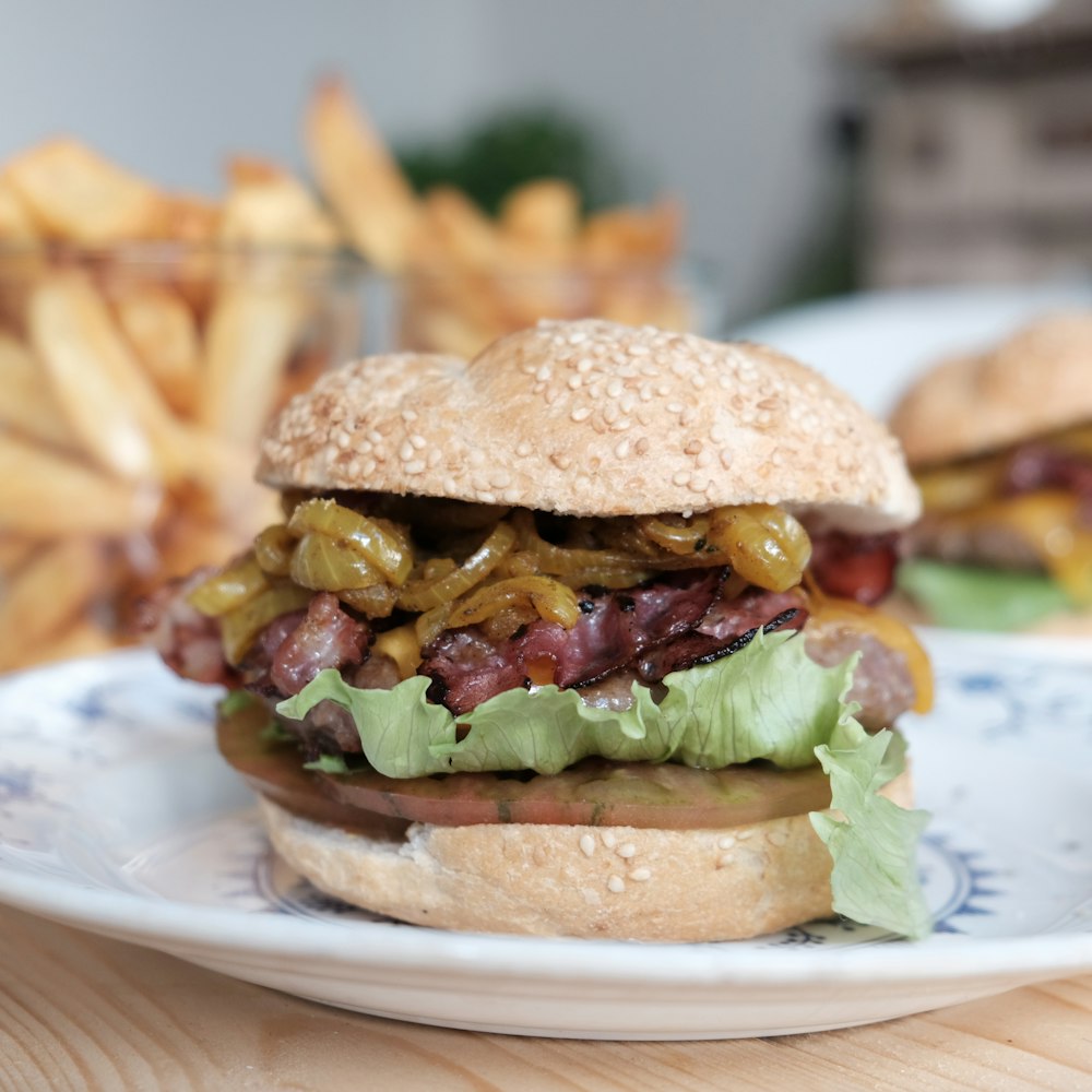 burger with lettuce and tomato on white ceramic plate