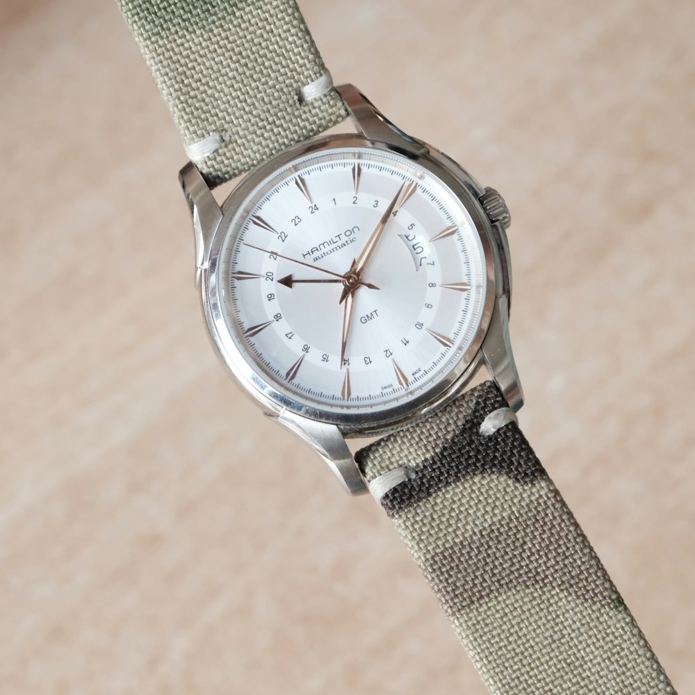 silver and white analog watch at 10 10